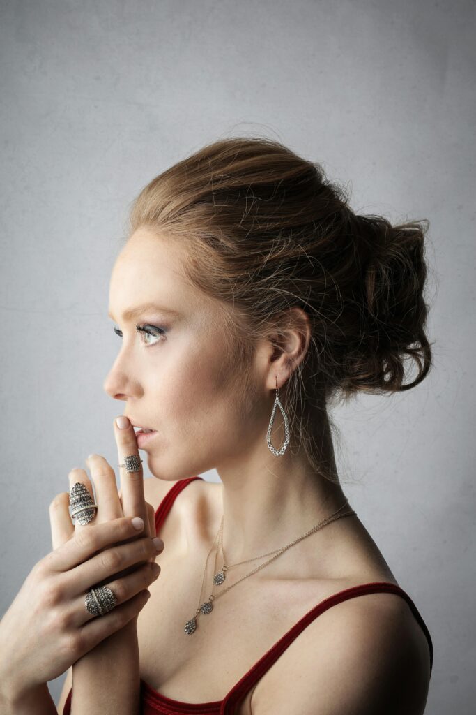 pexels-photo-3776155-3776155 Profile of a woman in minimal jewelry and red top gazing thoughtfully.