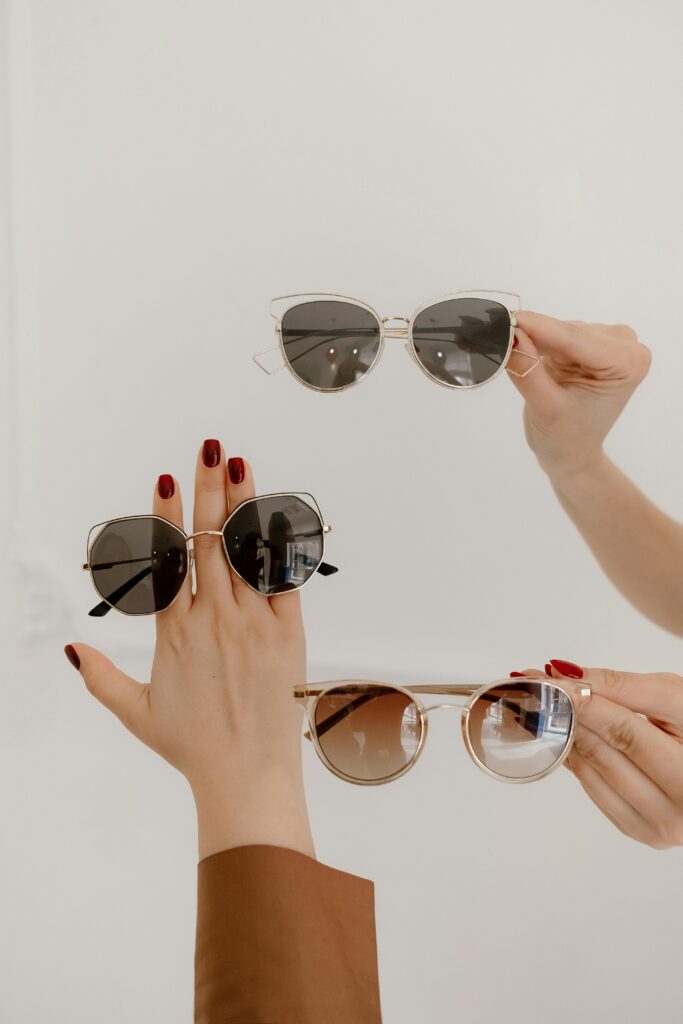 pexels-photo-7819283-7819283 Close-up of elegant hands showcasing trendy sunglasses with manicured nails.